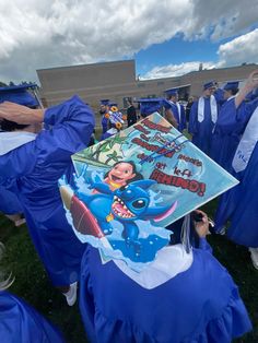 graduates in blue caps and gowns are holding up their diplomas at the graduation ceremony