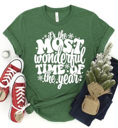 ~~It's The Most Wonderful Time Of The Year~~ Screen printed design on a soft style unisex fit tee.  Choose your shirt color and style from the menu. The design is white as shown. *2nd size chart is for a sweatshirt option. **Example shirt color is heather grass green** SHIRT DETAILS: -Heather Colors : 52% combed ringspun cotton & 48% polyester  -Solid Colors - 4.3 oz 100% preshrunk cotton  -Shoulder-to-shoulder taping -Double-needle stitched sleeves and bottom hem -Unisex sizes are similar to a Green Christmas Crew Neck T-shirt, Relaxed Fit Crew Neck T-shirt For Christmas, Christmas Crew Neck T-shirt With Letter Print, Christmas Cotton T-shirt With Text Print, Christmas Green Cotton T-shirt, Green Graphic Print T-shirt For Winter, Winter Green Graphic Print T-shirt, Christmas Green T-shirt With Letter Print, Green Christmas T-shirt With Letter Print