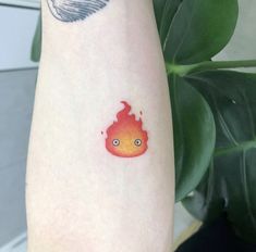 a red and orange fire tattoo on the left arm, with a finger print behind it