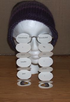 a white mannequin head wearing glasses and a purple hat