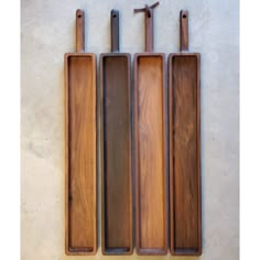 three wooden utensils are lined up in a row