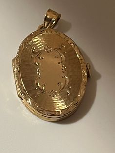 This hand-made oval locket is as sentimental and unique as it gets. It is a perfect Mother's Day present. It is made of 14 karat gold. It is both beautiful and functional. Most lockets can hold 2 pictures but this one can hold 4 special photos close to your, or your loved one's heart! The photos are easy to slip through slots at top of locket. It is hard to match the workmanship of this locket and it's engraving. It was crafted by a very talented jeweler in the NYC jewelry district between 1970 - 1980. Lockets are his legacy and his remaining inventory is being sold on this site. Most are one of a kind and will not be available after it is sold. The best jewelers are in awe of the workmanship and you will always get compliments. This precious locket and can easily become a heirloom that ca Elegant Oval Link Locket Necklace, Luxury Yellow Gold Oval Locket Necklace, Luxury Oval Locket Necklace As Gift, Elegant Gold Locket Necklace With Oval Link, Luxury Oval Jewelry For Keepsake, Elegant Gold Oval Link Locket Necklace, Elegant Engraved Locket Necklace With Oval Link, Elegant Oval Pendant Locket Necklace For Keepsake, Elegant Oval Link Locket Necklace For Wedding