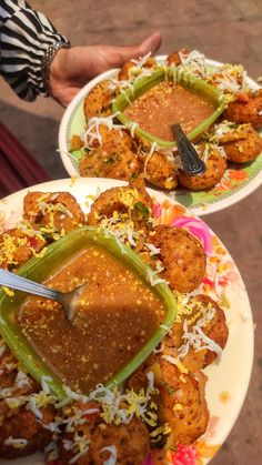 two plates with food on them, one is covered in sauce and the other has vegetables