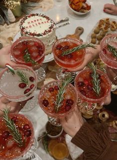 several people holding up wine glasses filled with drinks