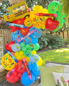 a bunch of balloons are stacked on top of each other in front of a house