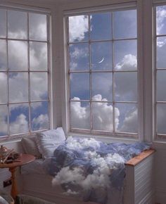 there is a bed with clouds in the window