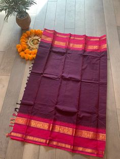 These Kanchi sarees are known for their tradition, comfort and simplicity. The saree is handwoven and comes with an intricately woven border. This saree comes in eggplant shade with pink border and a running blouse piece.  Pico, falls and blouse stitching can be done at an extra cost. Festive Saree With Border For Rituals, Traditional Saree With Border For Rituals, Traditional Drape Saree With Border For Rituals, Traditional Saree For Rituals With Border Detail, Traditional Wear With Border For Diwali Rituals, Traditional Wear For Diwali With Border Details, Traditional Wear For Diwali Rituals With Border Details, Rituals Saree With Border, Anarkali Style Saree With Weaving Work For Puja