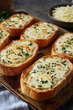 several pieces of bread with cheese and herbs on top