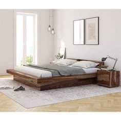 a bed sitting on top of a wooden floor next to a dresser and lamp in a bedroom