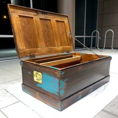 an old wooden chest sitting on top of a white tile floor next to a building