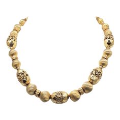 This is part of Chairish’s Costume Jewelry assortment.  1960s goldtone single strand of textured big beads necklace with hook clap and flower? dangle at the end. Marked "Monet." Doubled measures: 8 1/4 inches long. Biggest beads: 5/8 inches by 7/8 inches. Smaller round beads: 1/2 inch across. Condition: Very good; minor wear if any. Vintage Yellow Gold Single Strand Necklace, Gold Metal Necklace With Polished Beads, Gold Necklace With Polished Metal Beads, Vintage Polished Beads Necklaces, Vintage Yellow Gold Polished Bead Necklace, Vintage Yellow Gold Beaded Necklaces With Round Beads, Vintage Yellow Gold Necklaces With Polished Beads, Vintage Gold Beaded Necklace With Faceted Beads, Vintage Gold Beaded Necklaces With Faceted Beads