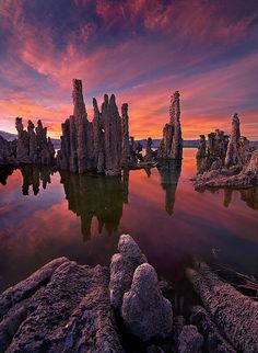 the monolithe rock formations are reflected in the still water at sunset or dawn