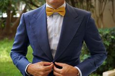 Give an extravagant tone to formal styles with OTAA’s Gold Satin Bow Tie. Regarded for centuries as being synonymous with nobility and wealth, the gold palette of this pre-tied bowtie will give your suits a lavish appeal. Stitched by hand and tailored from a fine satin fabric, this Gold Satin Bow Tie is as high-quality as they come. The smooth body and subtle lustre finish of this pre-tied bowtie will give your formal styles an extravagant outlook. Let it add confidence to your boardroom looks a Gold Wedding Bow Ties, Elegant Gold Bow With Ties, Gold Satin Bow Tie, Gold Satin Bow Tie For Black-tie Events, Formal Fitted Yellow Bow Tie, Bowties Men's, Blue Tux, Yellow Palette, Yellow Bow Tie