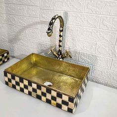 two black and white checkered sink in front of a brick wall