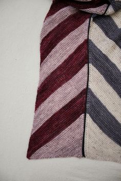 a close up of a tie on top of a white surface with a black and red stripe