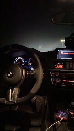 the interior of a car with dashboard lights and gauges in it at night time