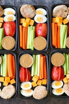 four trays filled with different types of food and veggies in them,