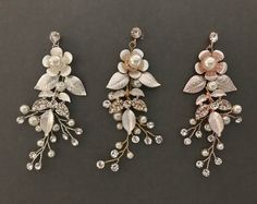 three pairs of earrings with flowers and leaves on them, all decorated with pearls and swarongs