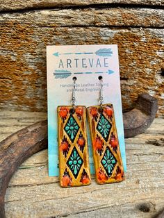 the earrings are made out of wood and have colorful designs on them