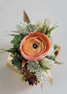 an orange and white flower bouquet with greenery