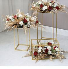 two gold plant stands with red and white flowers