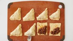 six pastries are arranged on a baking sheet with a knife and fork in the middle