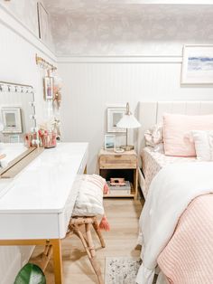 a bedroom with a bed, desk and mirror on the wall next to each other