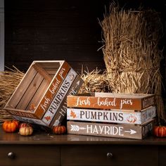 pumpkins, hay bales and wooden boxes sit on a table