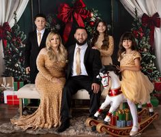 a family posing for a christmas photo in front of presents