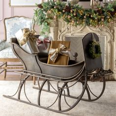 a sleigh filled with presents in front of a fireplace