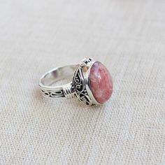 Gemstone - RhodochrositeGemstone Size - 12x16 oval Metal - Sterling SilverRing Size - All sizes AvailableNatural pink rhodochrosite sterling silver handmade ringRhodochrosite attracts love by opening up the heart chakras with its healing vibrations. It gives us the inner strength to take another chance at love because even if you fall, the Rhodochrosite crystal will always catch you.The ring can be customized on request and gemstone can be switched to any gemstone you want. Feel free to contact Adjustable Oval Cabochon Gemstone Jewelry, Oval Cabochon Crystal Ring As Gift, Adjustable Oval Pink Jewelry, Oval Natural Stones Jewelry For Wedding, Adjustable Pink Oval Jewelry, Pink Adjustable Oval Jewelry, Silver Rhodonite Jewelry With Natural Stones, Silver Jewelry With Natural Stones And Rhodonite, Elegant Rhodonite Jewelry Gift