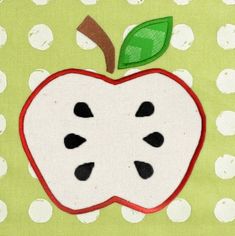 an apple applique on a green background with white polka dots