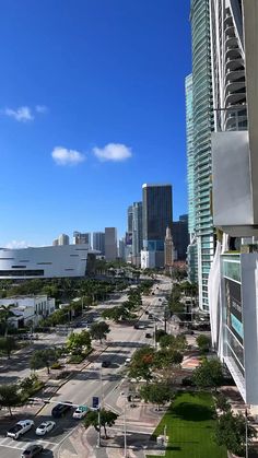 an aerial view of a city street with tall buildings and palm trees in the foreground