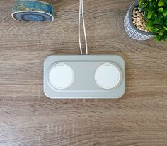 the electronic device is sitting on the table next to a potted plant and other items