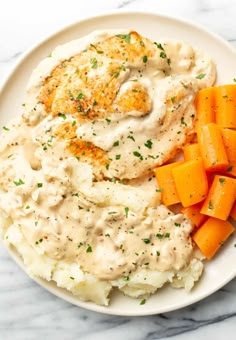 a white plate topped with mashed potatoes and carrots