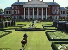 an artist's rendering of a person riding a horse in front of a large building