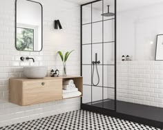 a white bathroom with black and white tiles on the floor, sink, mirror and shower stall