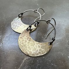 Over the years, my Crescent earrings have become our most popular and recognizable style! They are often the "first-pair" of earrings that people get for themselves or to gift another to start their collections. We make them in 4 sizes. Suspended from Sterling Silver wire and Sterling Silver earwires. Regardless of which size you choose, they are all amazingly lightweight and perfect as your "every day" earrings! Tiny = 3/4" wide x 1/2" tall & hang 1 3/8" from earwire to the bottom of the cresce Handmade Brass Earrings For Everyday Wear, Vintage Pierced Jewelry For Everyday, Vintage Everyday Pierced Jewelry, Vintage Everyday Jewelry, Nickel Free Brass Dangle Earrings, Hammered Drop Wrap Earrings As A Gift, Hammered Drop Wrap Earrings For Gift, Unique Crescent Earrings As Gift, Unique Small Hoop Jewelry With Ear Wire