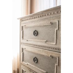 an old white dresser with drawers and knobs