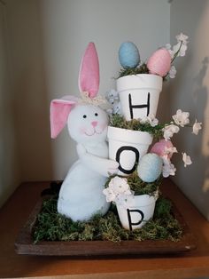 an easter decoration with bunny and flowers on a shelf