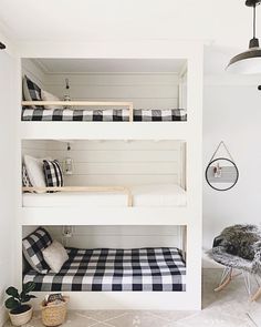 a room with bunk beds and black and white checkered sheets on the bedding