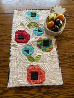 a bowl of fruit sitting on top of a table next to a piece of cloth