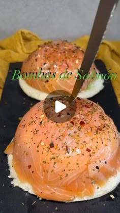 two bagels with salmon on them are being cut