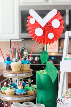 some cupcakes are stacked on top of each other in front of a cake stand