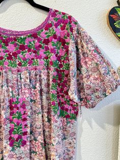 Our San Antonino dresses are unique, beautiful and perfect for any fiesta, a day at the beach or a formal event. You can easily dress it up or dress it down. Our dresses are completely hand embroidered by Artisans in Oaxaca, Mexico. It takes approximately 1 month to complete one dress.  Our San Antonino dresses are one of a kind. You will fall in love with every single detail. Each dress is hand embroidered on front chest area, sides and back with tiny floral designs inspired by the flowers in t Pink Floral Embroidered Short Sleeve Dress, Pink Short Sleeve Dress With Floral Embroidery, Short Sleeve Pink Dress With Floral Embroidery, Festive Dress With Multicolor Floral Embroidery, Festive Dress With Multicolor Embroidery And Floral Print, Pink Short Sleeve Festive Dress, Pink Festive Short Sleeve Dress, Festive Pink Short Sleeve Dress, Pink Festive Dress With Short Sleeves