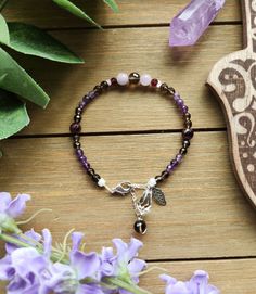 "This beaded bracelet features a lovely mix of faceted Smoky Quartz, faceted Amethyst, tiny Herkimer Diamonds, faceted Garnet in two sizes, and beautiful Kunzite beads. It is accented with a clear Swarovski crystal, a silver plated Leaf charm, and Smoky Quartz bead. It measures approximately 7\" (inches) in length, with an additional 1\" of silver chain for sizing. The bracelet clasps together with a silver lobster clasp." Bohemian Faceted Crystal Bracelet With Round Beads, Faceted Bead Crystal Bracelet Gift, Spiritual Faceted Beads Crystal Bracelet For Jewelry Making, Amethyst Faceted Beaded Bracelets For Gifts, Faceted Amethyst Beaded Bracelets As A Gift, Amethyst Faceted Beads Bracelet As Gift, Amethyst Faceted Beads Bracelet For Gift, Amethyst Bracelets With Faceted Round Beads, Amethyst Crystal Bracelet With Faceted Beads As Gift