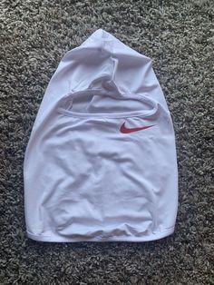 a white nike hoodie laying on the floor in front of a carpeted area