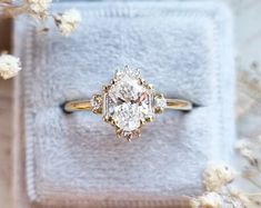 an engagement ring sitting on top of a white towel next to some baby's breath flowers