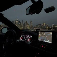 the dashboard of a car with city lights in the background