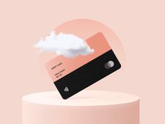 a card with a cloud floating out of it on top of a pink surface,